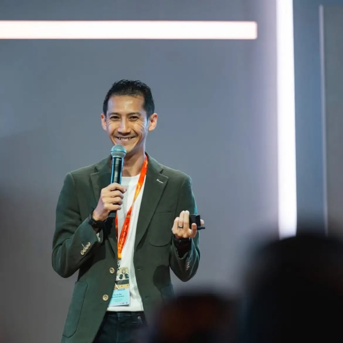 Yuda Foo speaking on stage at a conference